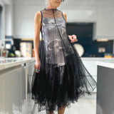 Avant-Garde Black Plaid Tulle Midi Dress featuring an edgy design with a fashion-forward aesthetic, showing details like shoulder accents and a defined waist, paired with stylish accessories such as sunglasses and headgear.