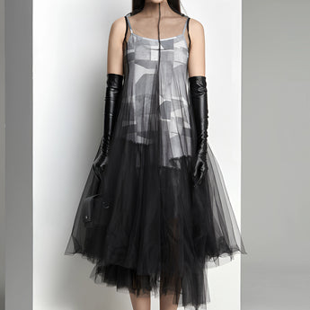 Avant-garde black plaid tulle midi dress featuring long sleeves and a defined waist, worn by a model with black hair, showcasing a unique and edgy fashion statement.