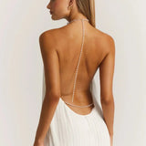 Back view of a backless white mini dress featuring a pleated skirt and delicate pearl straps, designed as party wear.