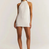 Backless white mini dress featuring a pleated skirt, pearl straps, and sleeveless design, ideal for party wear.