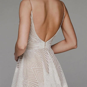 Backless white sequin evening gown in an elegant Art Deco style, featuring a fitted silhouette with a high neck, long sleeves, and intricate sequin detailing.