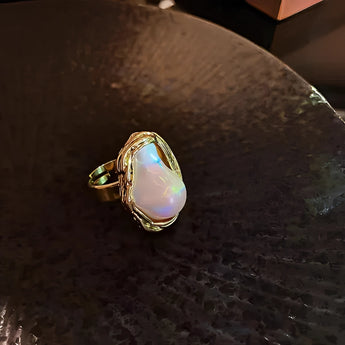 Luxury gold cocktail ring for women featuring a unique baroque pearl, oval gem, and intricate design.
