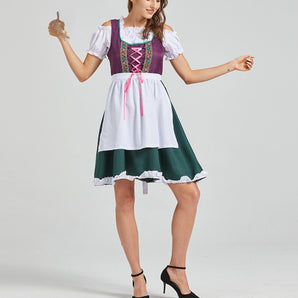 
Woman wearing a green and purple dirndl dress with white accents, featuring a fitted bodice and full skirt, styled for a Bavarian Oktoberfest theme.
