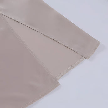 Beige adjustable strap cami with a zipper, featuring a versatile and minimalist design.