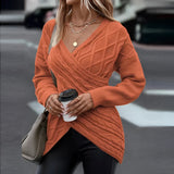
A woman wearing a beige crew neck sweater paired with jeans. She is accessorized with sunglasses and styled with a casual hairstyle, showcasing a trendy fall fashion look.