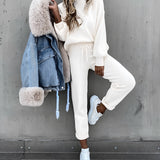Beige crew neck t-shirt made of soft cotton, ideal for minimalist everyday wear, shown in a fashion photograph with jeans and shoes.