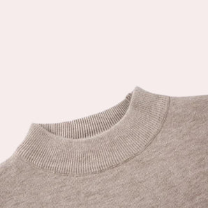 Beige crewneck ribbed sweater with long sleeves displayed against a neutral background.