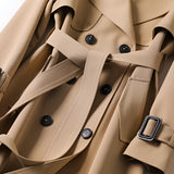 Beige double-breasted long trench coat with belt, featuring a classic collar and long sleeves, styled for luxury fall fashion.