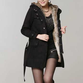 Beige fur-lined women's trench coat with a luxurious winter design, featuring long sleeves and a tailored fit, worn by a woman accessorized with a stylish hat.