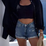 Beige knit crop top worn by a smiling woman, styled with white shorts, showcasing a chic summer fashion look.