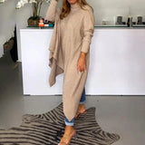 Beige knit oversized cardigan on a woman standing, showcasing its long sleeves and relaxed fit, ideal for fall fashion.