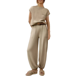 Woman wearing a beige knit top with long sleeves and high waist wide leg trousers in khaki, posing casually.