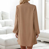 
A beige lantern sleeve shirt dress with a casual button-front design, featuring a tailored collar and fitted waist, styled as a mini dress.