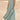 Beige linen dress with pockets, worn by a person, featuring a comfortable design suitable for eco-friendly summer fashion. The dress is styled with a green pin and is available in size 5XL.