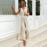 Apricot beige linen pantsuit with a sleeveless crop top and high-waisted trousers, worn by a smiling person standing confidently.