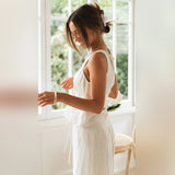 Beige linen pantsuit featuring a sleeveless crop top and high-waisted trousers, worn by a model.