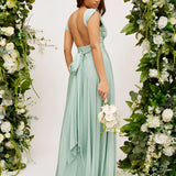 Beige maxi dress featuring a crisscross back and tie waist, suitable for a wedding guest, with floral design and elegant one-piece garment style.