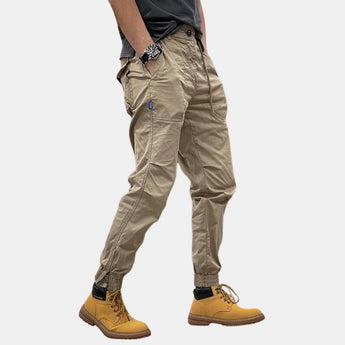 Men's slim fit cargo pants in beige featuring a durable design with multiple pockets, suitable for outdoor use.