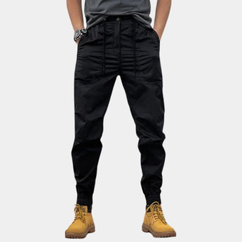 Men's black slim fit cargo pants with multiple pockets, designed for outdoor wear. The pants are shown in a 3XL size, highlighting the durable fabric and fashion-forward design.