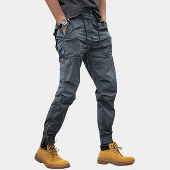 Beige men's slim fit cargo pants with multiple pockets, designed for outdoor wear, showcasing a stylish and functional look.