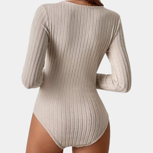 Beige ribbed long sleeve seamless fitted bodysuit for women, showcasing the arms, shoulders, and waist with a focus on the snug fit and elegant neckline.