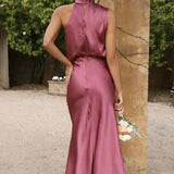 Beige sleeveless and backless midi dress suitable for weddings and cocktail events, showcasing elegant shoulder and waist design, with a fitted one-piece silhouette.