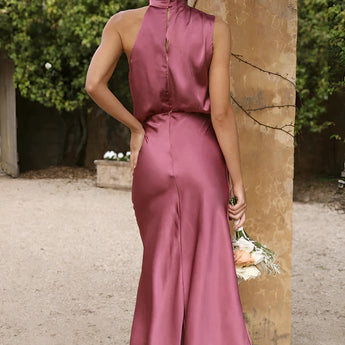 Beige sleeveless and backless midi dress suitable for weddings and cocktail events, showcasing elegant shoulder and waist design, with a fitted one-piece silhouette.