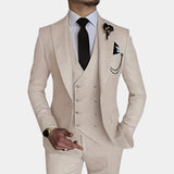 Men wearing a beige slim fit three-piece suit with a dress shirt, showcasing modern formal wear. The outfit includes a coat with long sleeves and a well-defined collar. The suit complements the wearer's fashion sense, with a watch visible on the wrist. The overall appearance is elegant, highlighting the suit's sophisticated design.