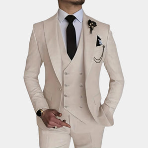Men wearing a beige slim fit three-piece suit with a dress shirt, showcasing modern formal wear. The outfit includes a coat with long sleeves and a well-defined collar. The suit complements the wearer's fashion sense, with a watch visible on the wrist. The overall appearance is elegant, highlighting the suit's sophisticated design.