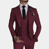 Men's three-piece suit in beige, featuring a slim-fit design, worn with a burgundy tie. The ensemble includes a blazer, dress shirt, and watch, highlighting modern formal wear. The wearer is posed with a focus on the sleeve, collar, and neckline details.