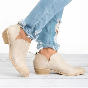 Beige suede ankle boots for women with a low heel, shown on a model wearing them.