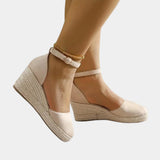 Beige suede espadrille wedge sandal with a closed toe and ankle strap, shown on a model wearing apricot color in size 40.