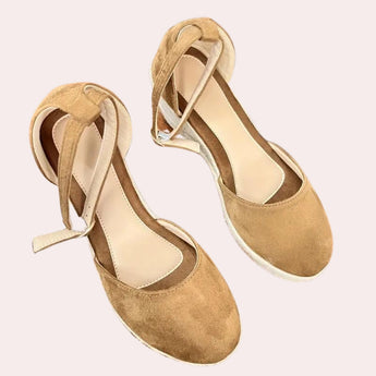 Beige suede espadrilles featuring a closed toe design, wedge heel, and an adjustable ankle strap, shown in a brown color variant and size 40.