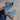 Beige suede women's ankle boots with a low heel and zipper, shown in a denim blue color variant, styled on a model's foot against a background that highlights the boots' elegant design and texture.