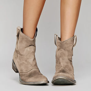 Beige suede women's low heel Western ankle boots being worn, showcasing their stylish design and comfortable fit.