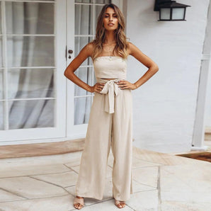 Beige sleeveless jumpsuit with a tie-waist design, featuring a tailored fit and suitable for elegant casual summer wear.