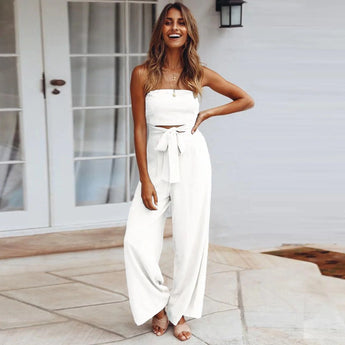 Beige tie-waist sleeveless jumpsuit worn by a smiling woman, showcasing elegant casual summer fashion design with emphasis on waist and neck areas.