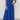 Blue V-neck wide-leg jumpsuit with short sleeves and a fitted waist, styled for an elegant formal summer look.