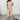 Beige V-neck wide-leg jumpsuit designed for elegant formal summer occasions, featuring short sleeves and a defined waist, modeled by a person standing upright.