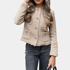 Beige women's bouclé double-breasted blazer with long sleeves and a structured collar, worn over a grey dress shirt and paired with denim jeans, showcasing chic fall outerwear style.