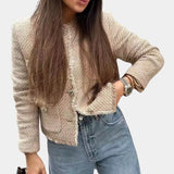 Beige women's bouclé double-breasted blazer worn by a model, showcasing chic fall outerwear fashion.