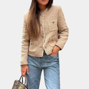 Beige women's bouclé double-breasted blazer with notched collar and long sleeves, styled as chic fall outerwear.