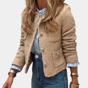 Beige women's bouclé double-breasted blazer with a tailored fit, featuring long sleeves and a classic collar, styled with jeans in a chic fall fashion setting.