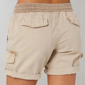 Beige women's cargo shorts with an elastic waist and pockets, lightweight fabric.