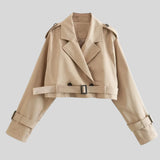 Beige cropped women's jacket with belted sleeves and a high collar, displayed hanging on a clothes hanger.