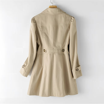 Beige women's double-breasted short trench coat with a fitted waist, featuring a classic collar and long sleeves, styled as fashionable outerwear.