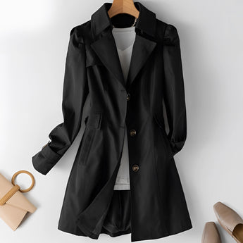 Beige women's double-breasted short trench coat with fitted waist, featuring a classic lapel collar and long sleeves.