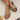 Beige women's flat buckle sandals with comfortable cork sole, shown on a model's feet.