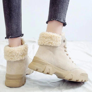 Beige women's fleece-lined winter ankle boots with plush chunky soles, shown worn with jeans.
