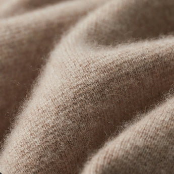 Beige women's lightweight casual linen blazer with a collarless open front design, displayed on a wooden surface.